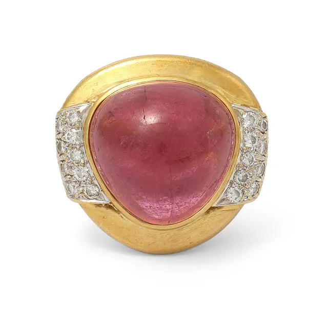 A tourmaline and diamond ring set with a cabochon pink tourmaline and numerous brilliant-cut diamonds weighing a total of app. 0.18 ct, mounted in 18k gold. Weight app. 22 g. W. 23 mm. Size 54.
