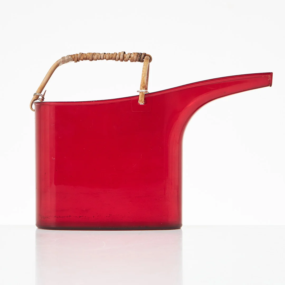 STIG LINDBERG. Vattenkanna, "Fontana", Gustavsberg, röd syrénplast, grepp i rotting, formgiven 1967. — Miscellaneous — Stockholms Auktionsverk Magasin 5