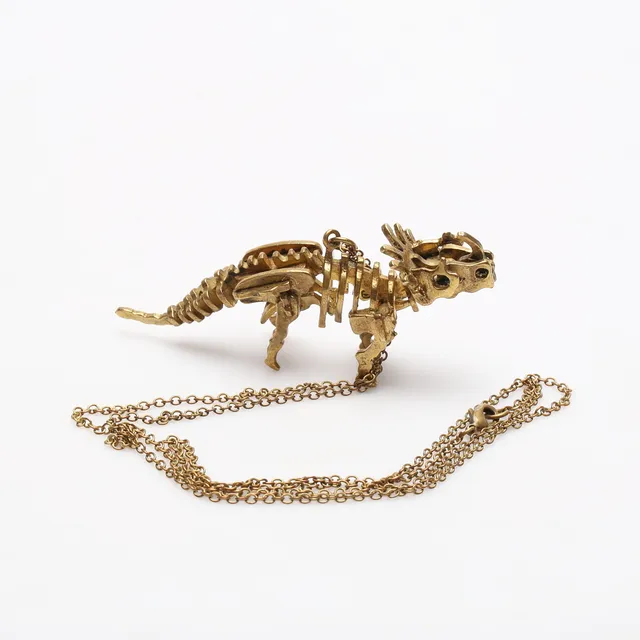 HALSBAND med HÄNGE, gulmetall, i form av dinosaur.