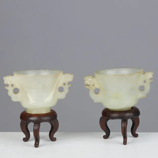 To små bægre af lys celadon jade med stande af træ, 19-20 årh. (2+2).