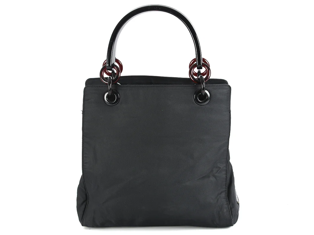 VÄSKA, PRADA, svart nylon, handtag i vinröd plast, 26x26x10cm. — Accessoarer/Väskor — Kaplans