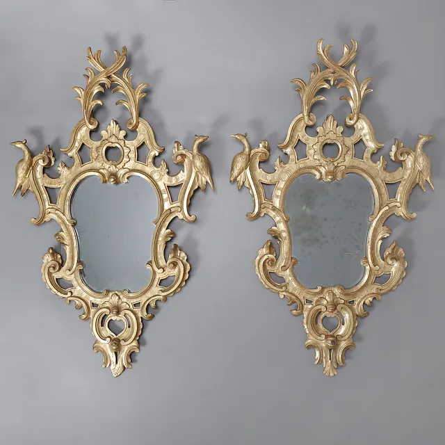 Pair of Ferdinand VI-Charles III ornamental mirrors in carved and gilt wood, 18th Century and later.