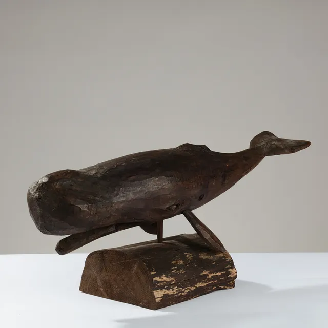 Stor skulptur af mørkbejdset træ forestillende kaskelothval.