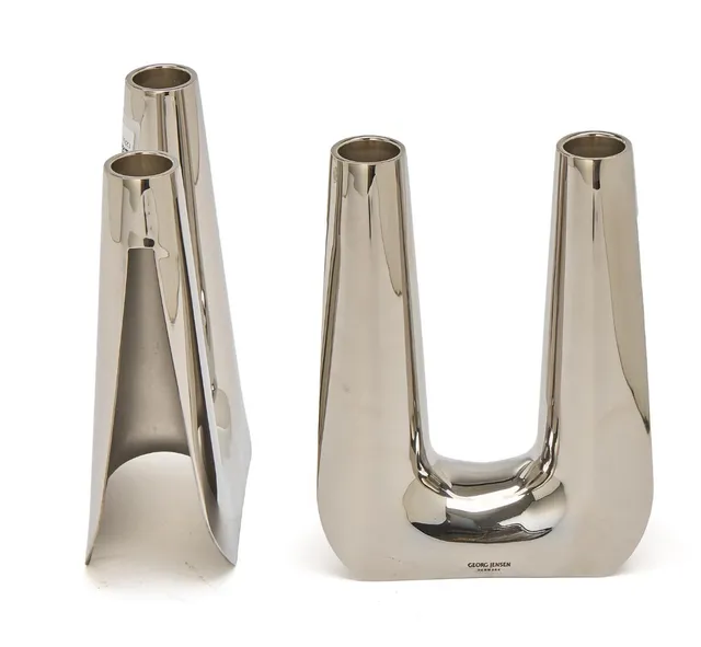 A pair of stainless steel candelabra. Smooth, slightly trumpet shaped light arms. Made and marked for Georg Jensen, Denmark. H. 17.5 cm. W. 13.3 cm. The inner diam. of candle holder 2.4 cm. (2)