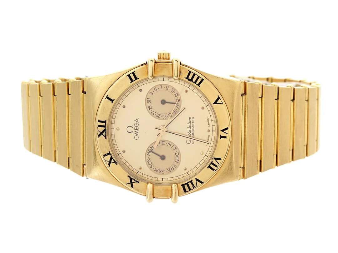 OMEGA, Constellation, "Uggla", Chronometer, Serie nr. saknas, Ref nr. BA 398.0142, Boett nr. 198.0142, herrur, 32,5 mm, 18K guld, quartz, safirglas, dag, datum, urverk ej signerat, integrerad originallänk, viklås, Ref nr. 396.1070, totalvikt 116,76 gram, ca 1985. — Klockor/Omega — Kaplans