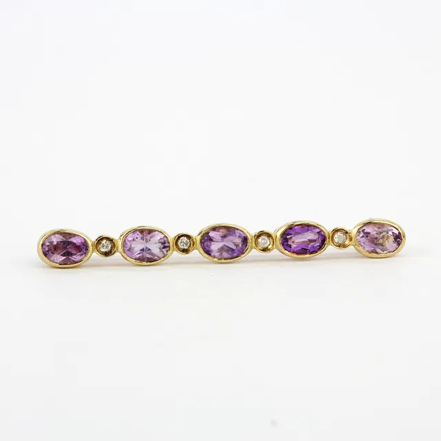 9CT YELLOW GOLD AMETHYST AND DIAMOND BROOCH.