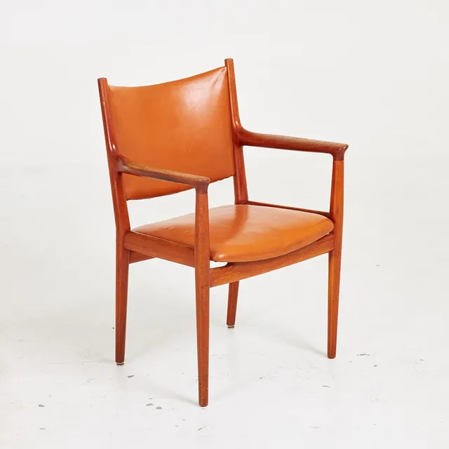 HANS J WEGNER. Karmstol, "JH 513", stomme i massiv teak, sits och rygg i konjakläder, Johannes Hansen, brickmärkt, formgiven 1960-tal, Danmark.