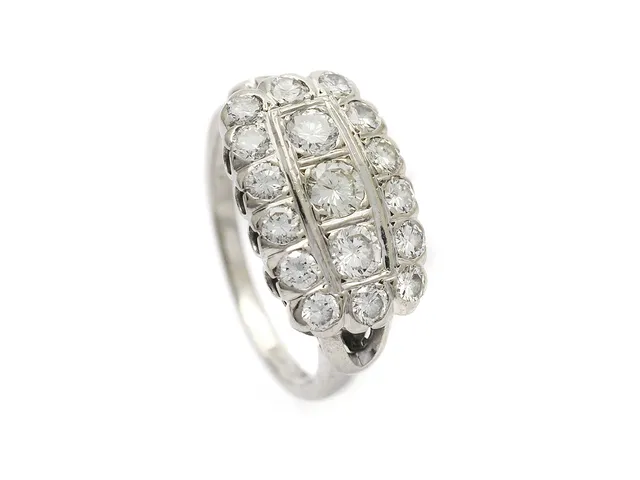 RING, 18K vitguld, 17 briljantslipade diamanter ca 1,06 ctv, ca TW-CR/VS-SI, slitna fasettkanter, tre av de mindre diamanterna är skadade och har ej åsatts något värde, två av de mindre diamanterna har skadade kuletter, stl 16 mm, vikt 5,8 g.