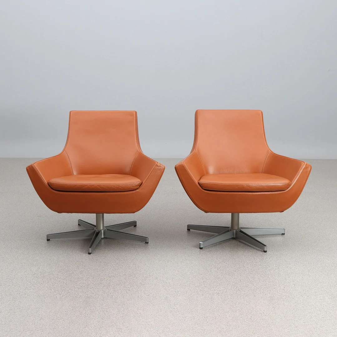 ROGER PERSSON. FÅTÖLJER, ETT PAR. Klädsel i brunt skinn, fötter i lackerad metall. "Happy Swing", Swedese. — Armchairs & Chairs — Skånes Auktionsverk