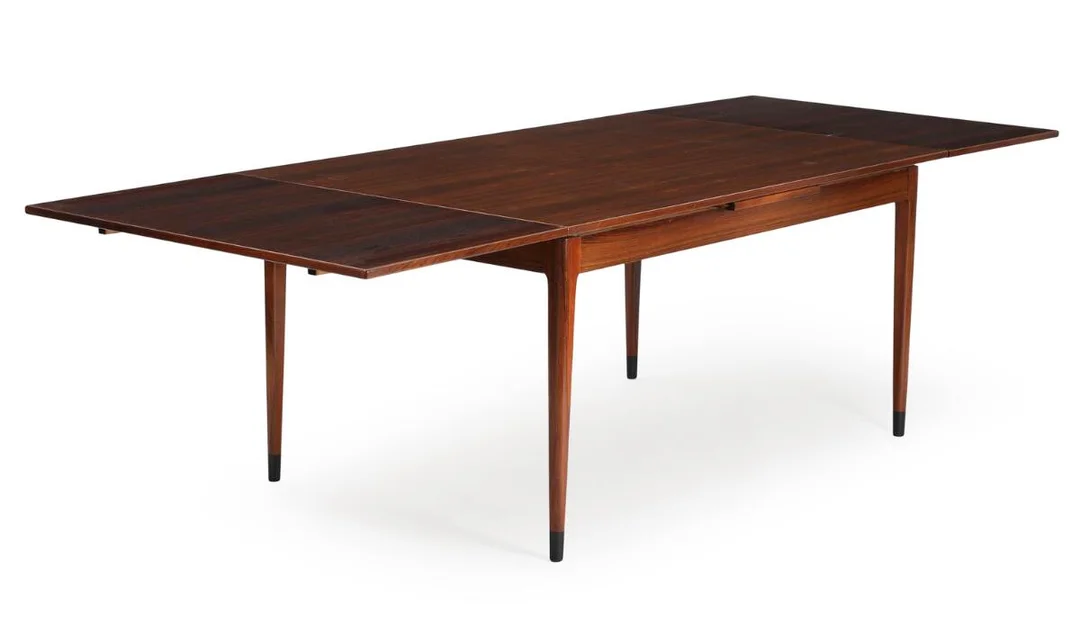 A rosewood dining table with extension, dark lacquered shoes. Manufactured and marked by J. L. Møller's Møbelfabrik. 1960s. H. 73. L. 150/264. W. 100 cm. — Modern Furniture — Bruun Rasmussen