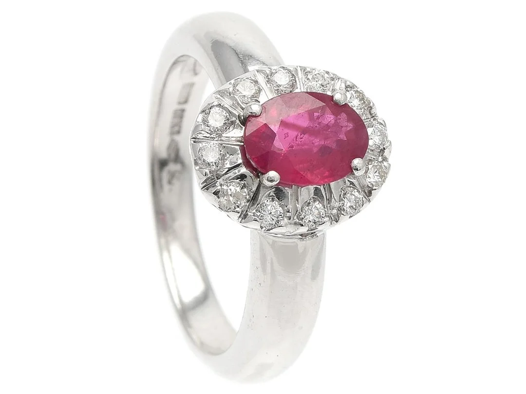 CARMOSÉRING, 18k vitguld, behandlad rubin ca 0,95 ct, 12 briljantslipade diamanter ca 0,24 ctv, ca TW/SI-P, stl 17,25 mm, vikt 5,6 g, en diamant skadad. — Smycken/Carmoséring — Kaplans