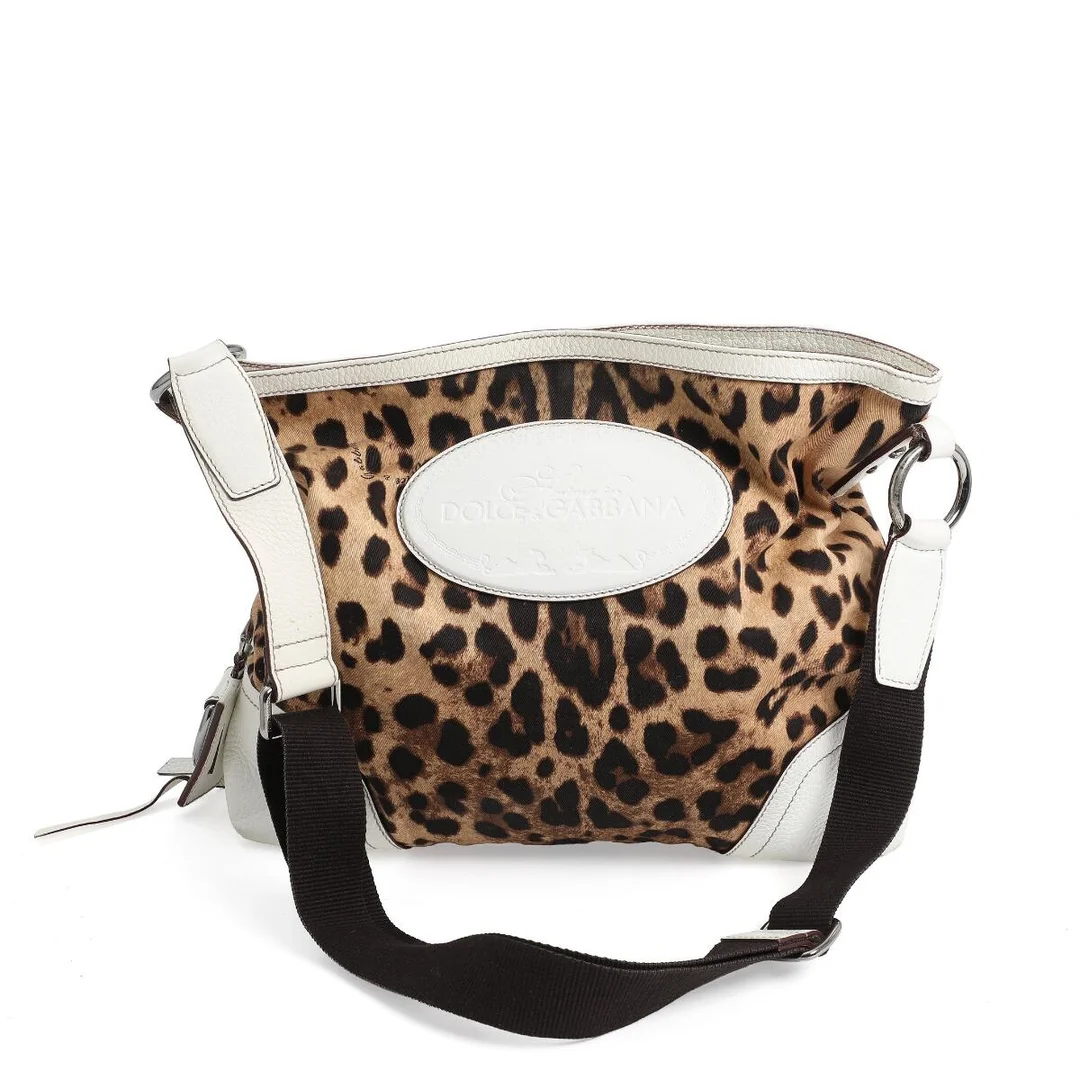 A bag of leopard print canvas with white leather trimmings, silver tone hardware, adjustable shoulder strap, one compartment with zipped pocket and dark brown lining. H. 35. W. 40. D. 9 cm. — Designer Handbags & Fashion — Bruun Rasmussen