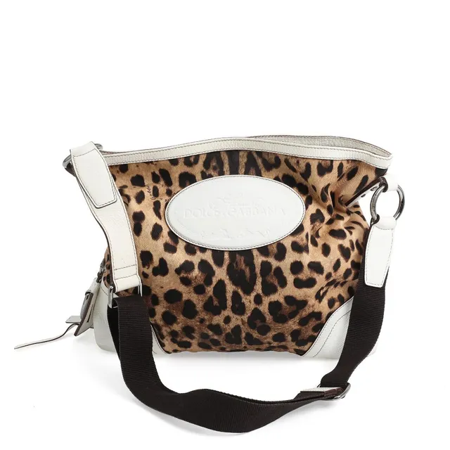 A bag of leopard print canvas with white leather trimmings, silver tone hardware, adjustable shoulder strap, one compartment with zipped pocket and dark brown lining. H. 35. W. 40. D. 9 cm.