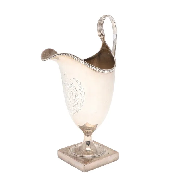 A GEORGE III SILVER HELMET SHAPE CREAM JUG, BY HESTER BATEMAN.