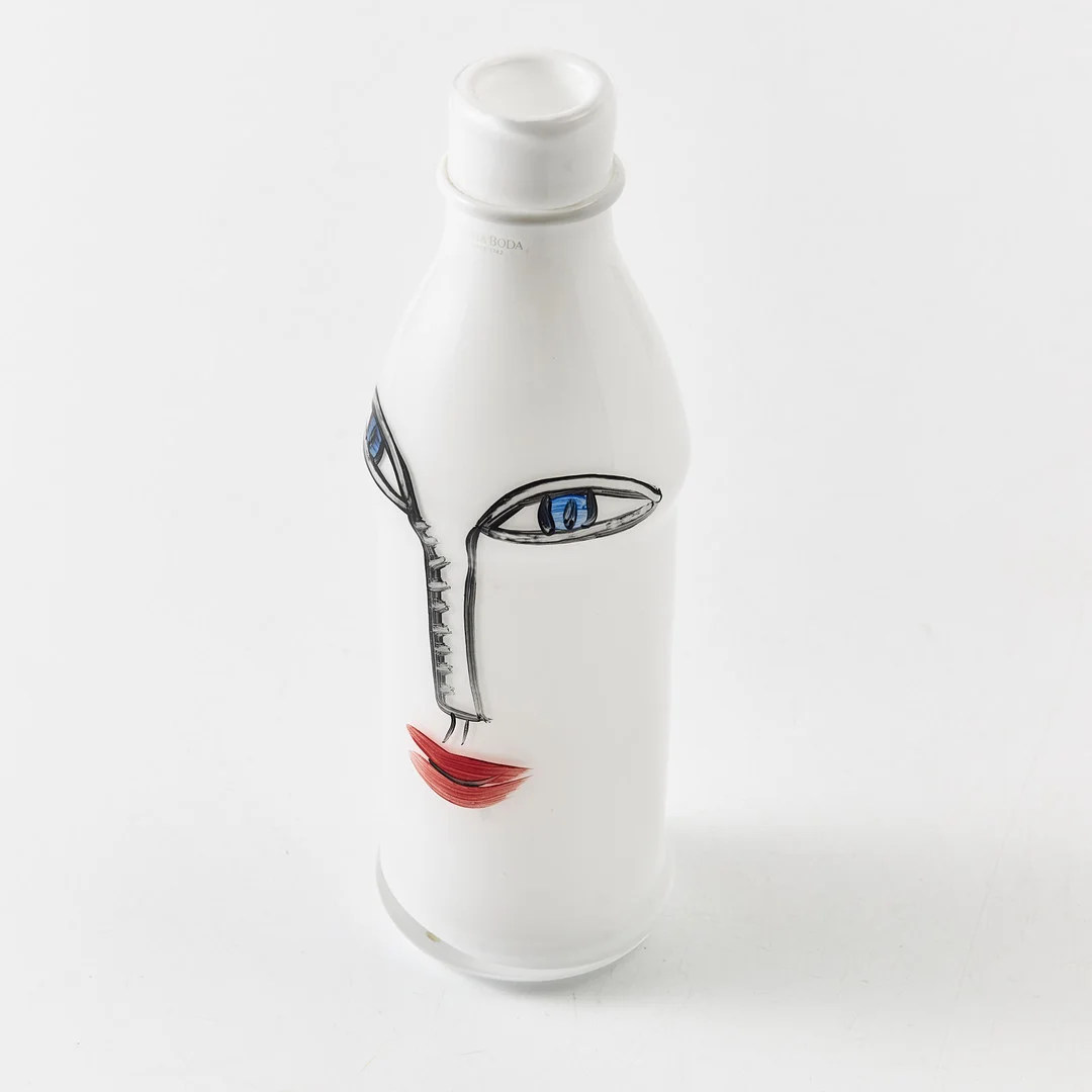 ULRICA HYDMAN-VALLIEN. Flaska, "petflaska" Kosta Boda, målad dekor av ansikte, signerad. I botten 7323030 Kosta Boda Lim. ed. 1000 Ulrica HV. — Art glass — Stockholms Auktionsverk Magasin 5