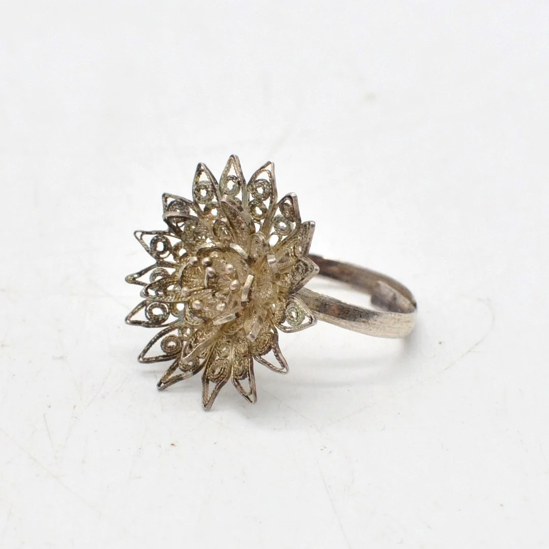 DESIGNERRING MIT FILIGRANER BLUME, STERLINGSILBER HANDGEMACHT, UM 1950ER, GRÖSSENVERSTELLBAR. — Rings — Kunst- und Auktionshaus Kleinhenz