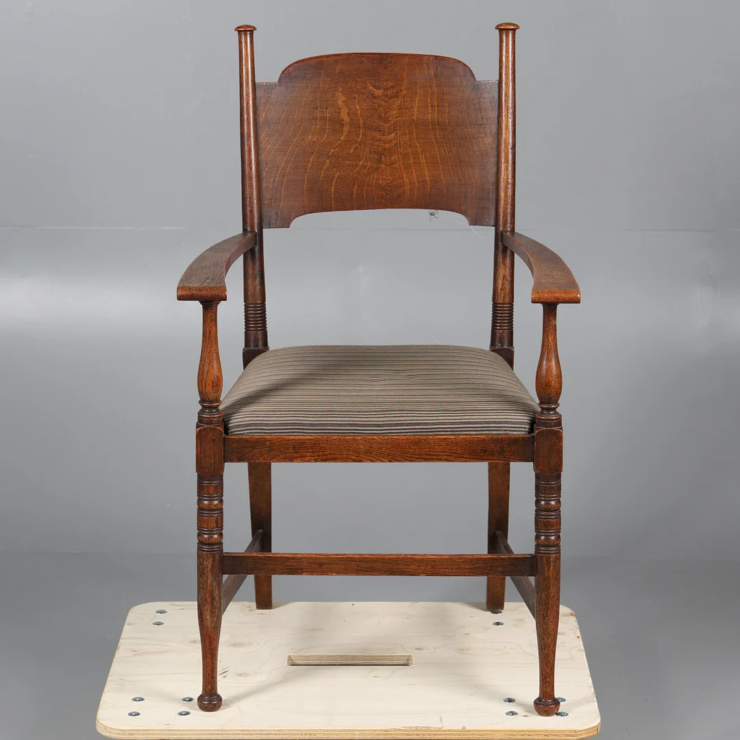 AN ARTS AND CRAFTS OAK OPEN ELBOW CHAIR PROBABLY BY WILLIAM BIRCH FOR LIBERTY & CO. — Armchairs & Chairs — Bishop & Miller