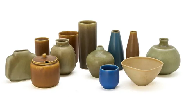 Nine vases and a bowl and a marmalade jar of stoneware, decorated with blue, grey-green, sand-coloured and brown glaze. Made and signed by Palshus, Denmark. Together with a cylindrical vase, decorated with yellow-brown glaze. Signed Palshus, KAS, Glostrup, Christmas 1969. H. 6–15 cm. (12)