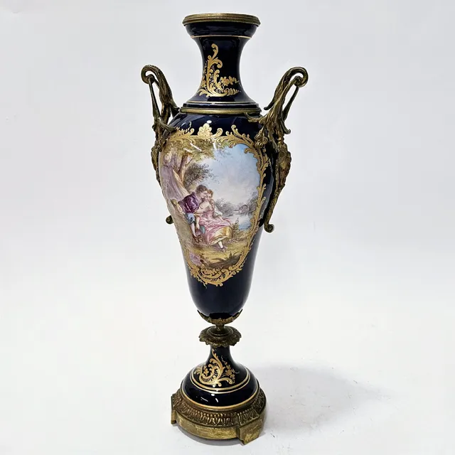 FIRMADO J. ROCHE. JARRÓN EN PORCELANA SEVRÉS, MEDALLONES CON ESCENA ROMÁNTICA Y PAISAJE, CON TAPA EMBELLECEDORES EN BRONCE DORADO.