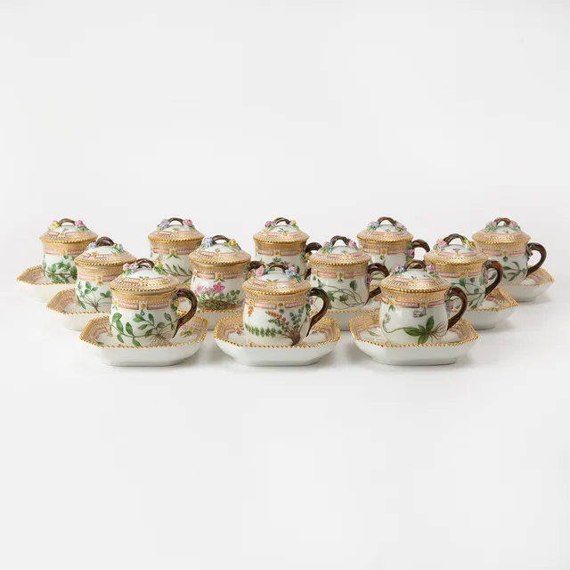 ROYAL COPENHAGEN. "Flora Danica", crèmekoppar med underfat, 12 stycken, porslin, Danmark, 1900-talets mitt, målad dekor av botanik, detaljer i guld, modellnr 3514, 3515.