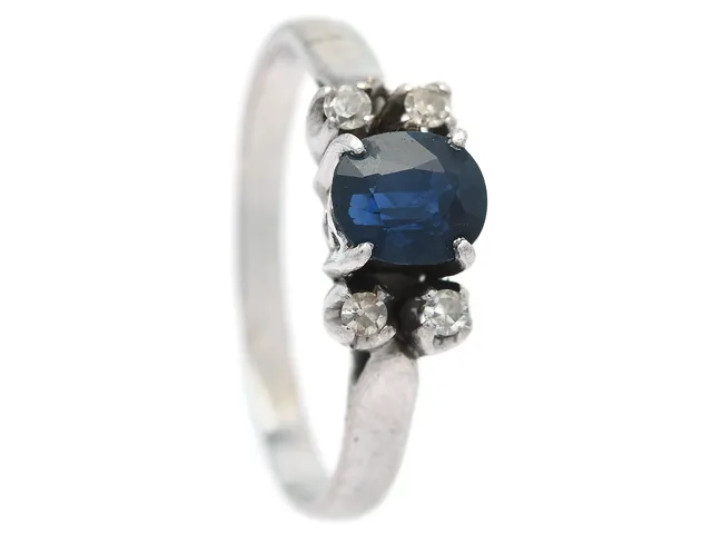 RING, 18K vitguld, ovalslipad blå safir ca 0,80 ct, 4 åttkantslipade diamanter ca 0,10 ctv, ca Cr-TCa(J-K)/SI, stl 18 mm, vikt 2,5 g, ena diamanten med nagg.
