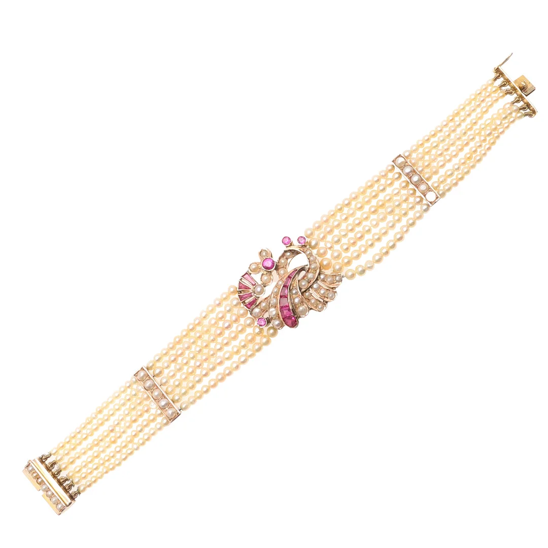 AN EARLY 20TH CENTURY CONTINENTAL CULTURED PEARL AND SYNTHETIC RUBY SIX STRAND BRACELET. — Bracelets — Lawrences Auctioneers
