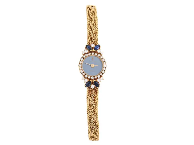 CORUM, damur, 15 mm, Boett nr. 369/993, 18K guld, quartz, safirglas, diamantkrans (24 st. 8/8, TW/VS, ca 0,20 ctv + 10 st briljanter, TW/VS, ca 0,26 ctv + 4 st. navelslipade safirer, ca 0,40 ctv), skadad urtavla, integrerad originallänk, längd 150-155 mm, totalvikt 22,1 gram, ca 1985, etui, ytterkartong.