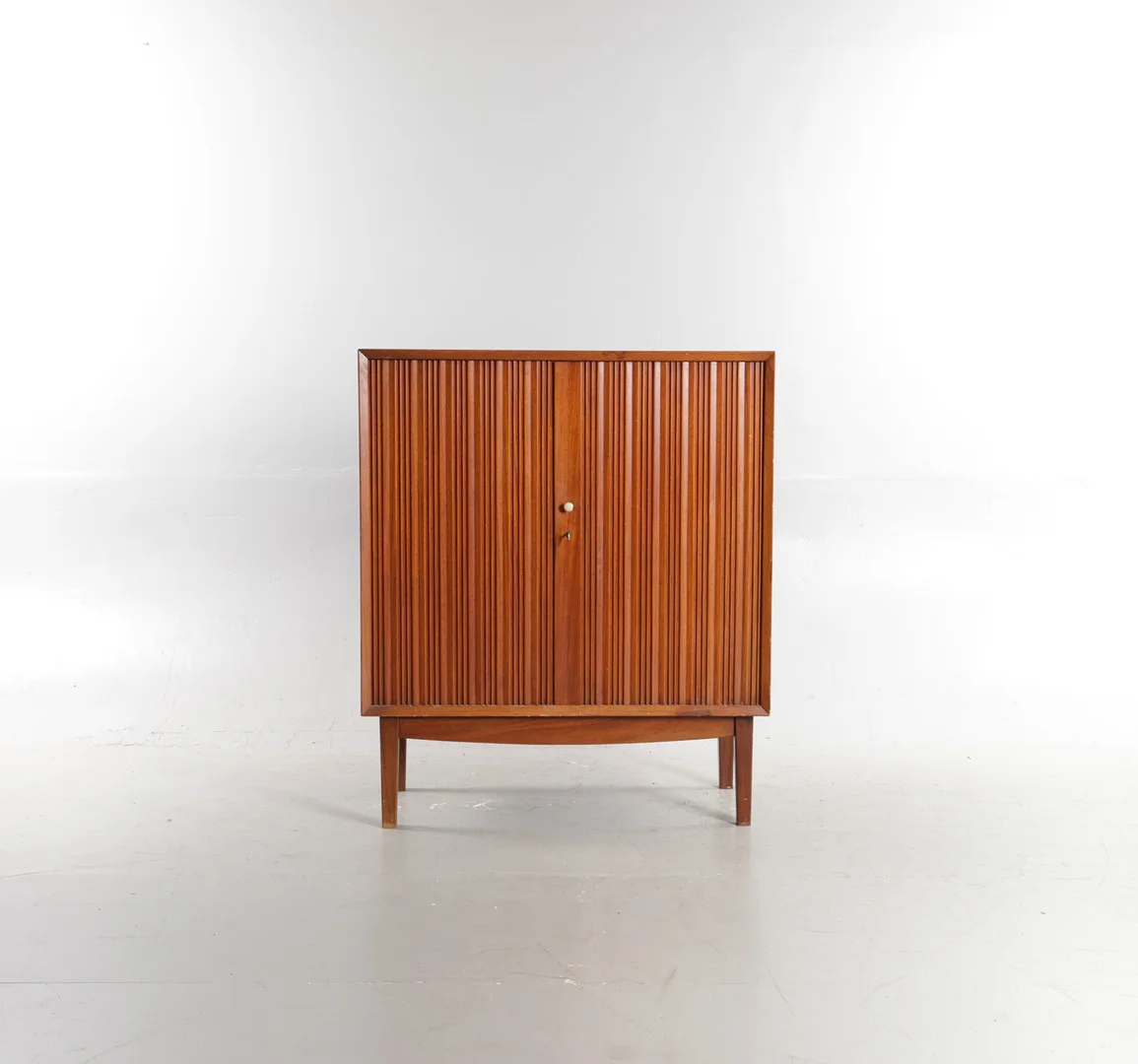 DANSK SNEDKERMESTER. Skab af mahogni, front med to låger med vertikale detaljer bag hvilke hylder og skuffer, stel med tilspidsede ben. Danmark, 1900-tallets midte. — Cupboards, Cabinets & Shelves — Woxholt Auktioner
