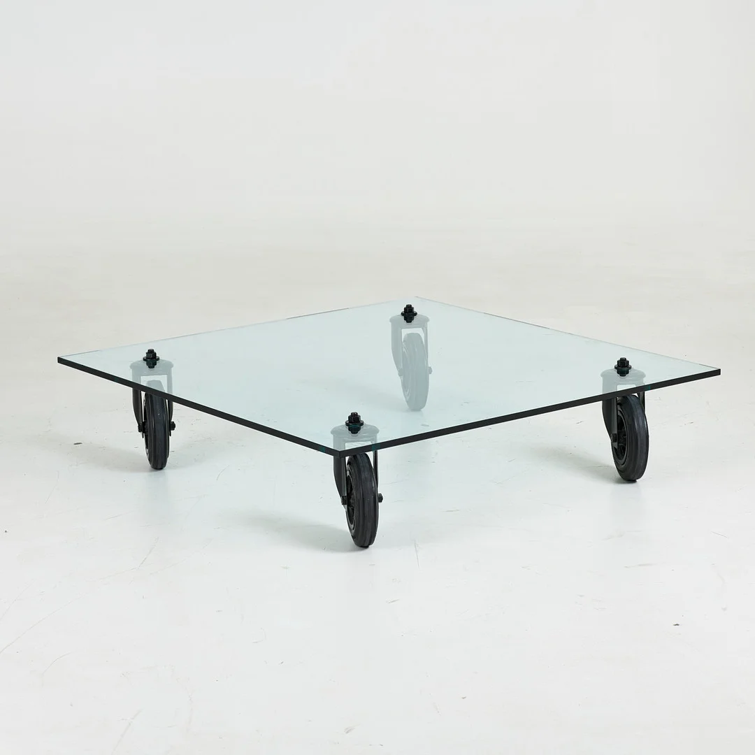 GAE AULENTI. ”Tavolo Con Ruote”, soffbord, för FontanaArte, glasskiva och hjul, Italien. — Tables — Stockholms Auktionsverk Sickla