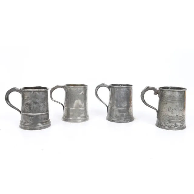 FOUR 19TH CENTURY PEWTER QUART TANKARDS.