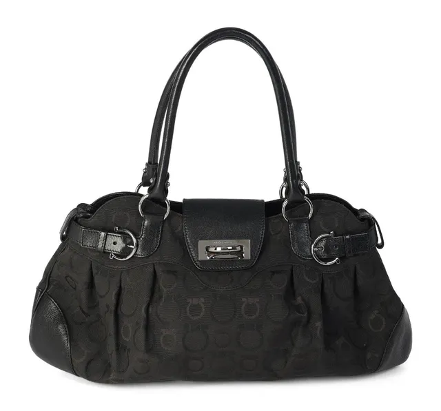 A shoulder bag in black monogram canvas with leather trim and silver-tone hardware, two handles, two buckles, one zippered compartment with an interior zippered pocket, two open pockets, and a black nylon lining. H. 26 × W. 45 × D. 20 cm.
