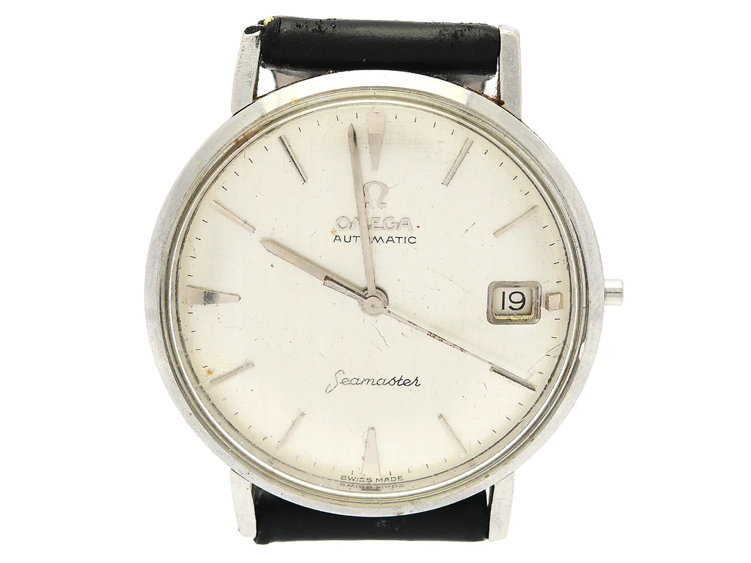 OMEGA, Seamaster, s.k. "Linen Dial", Cal 562, Serie nr. 19393469, Ref nr. CK 14770, Boett nr. 14770 SC-61, herrur, 34 mm, stål, automatisk, plexiglas, datum, saknar krona, skadad boett (böjda bandhorn), läderband, ca 1961. — Klockor/Omega — Kaplans