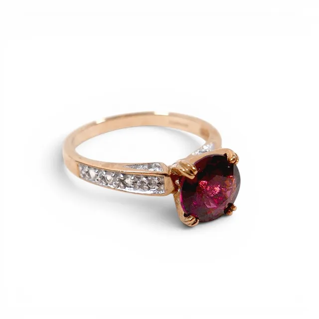 A 9CT GOLD RHODOLITE GARNET AND WHITE TOPAZ RING.
