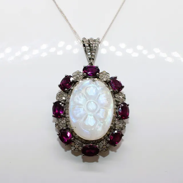 CARVED MOONSTONE , GARNET & DIAMOND PENDANT.