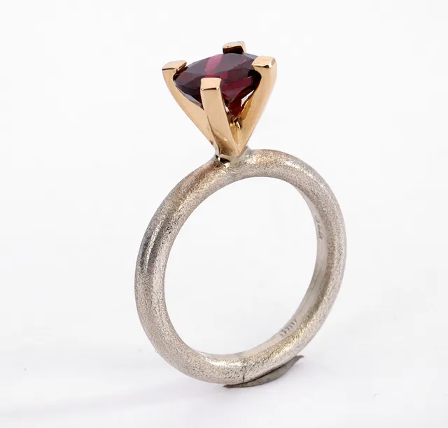 Solitaire ring made of 14 kt. gold and sterling silver adorned with precious garnet