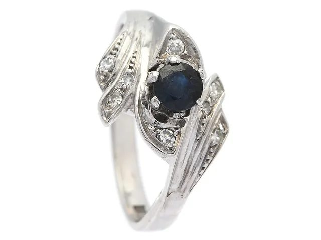 RING, 18K vitguld, blå safir ca 0,30 ct, 8 åttkantslipade diamanter ca 0,10 ctv, stl 17 mm, vikt 5,0 g, nagg.