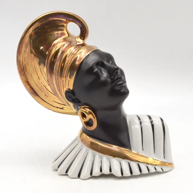 SKULPTURALE LAMPENFASSUNG AUS PORZELLAN, AFRIKANSICHE FRAU, GOLDSTAFFAGE, 20. JAHRHUNDERT.