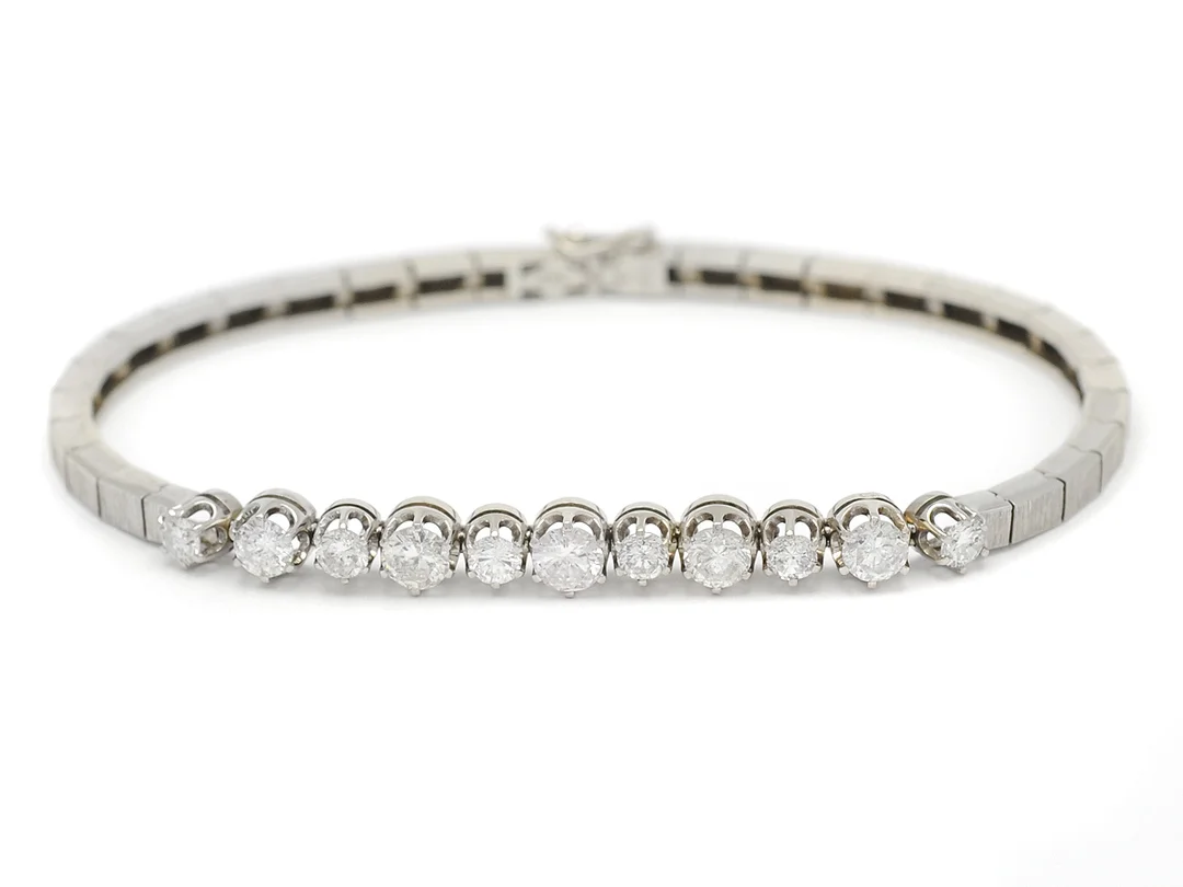 ARMBAND, 18K vitguld, 11 briljantslipade diamanter 2,14 ctv enligt gravyr, ca TW/P1, längd 18 cm, vikt 14,0 g, en diamant med nagg. — Smycken/Armband — Kaplans