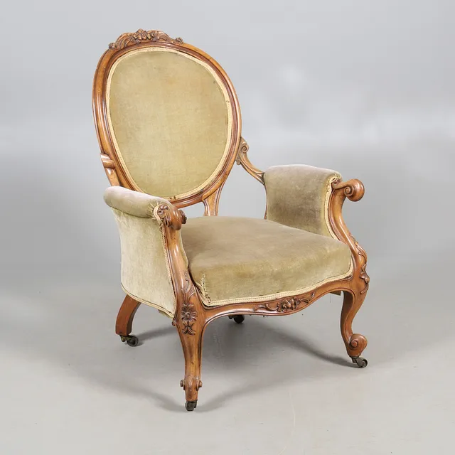 A VICTORIAN CARVED WALNUT OPEN ARMCHAIR.