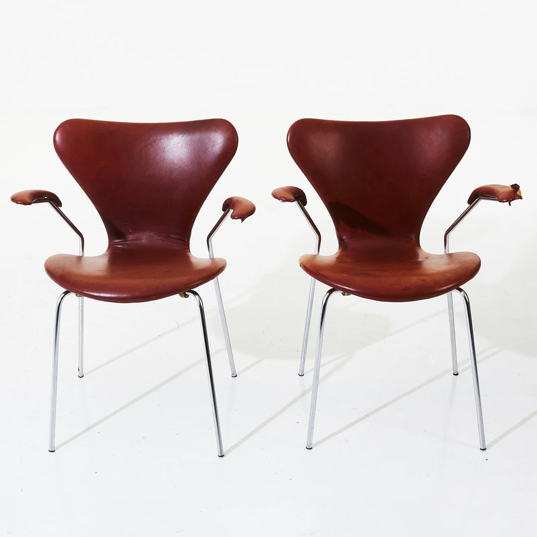 ARNE JACOBSEN. "Sjuan", karmstolar 1 par, Fritz Hansen, förkromad benställning, klädsel i brunrött läder, klädda armlän. — Armchairs & Chairs — Stockholms Auktionsverk Magasin 5