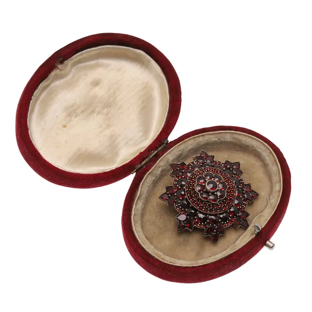 A GARNET AND SILVER GILT BROOCH.