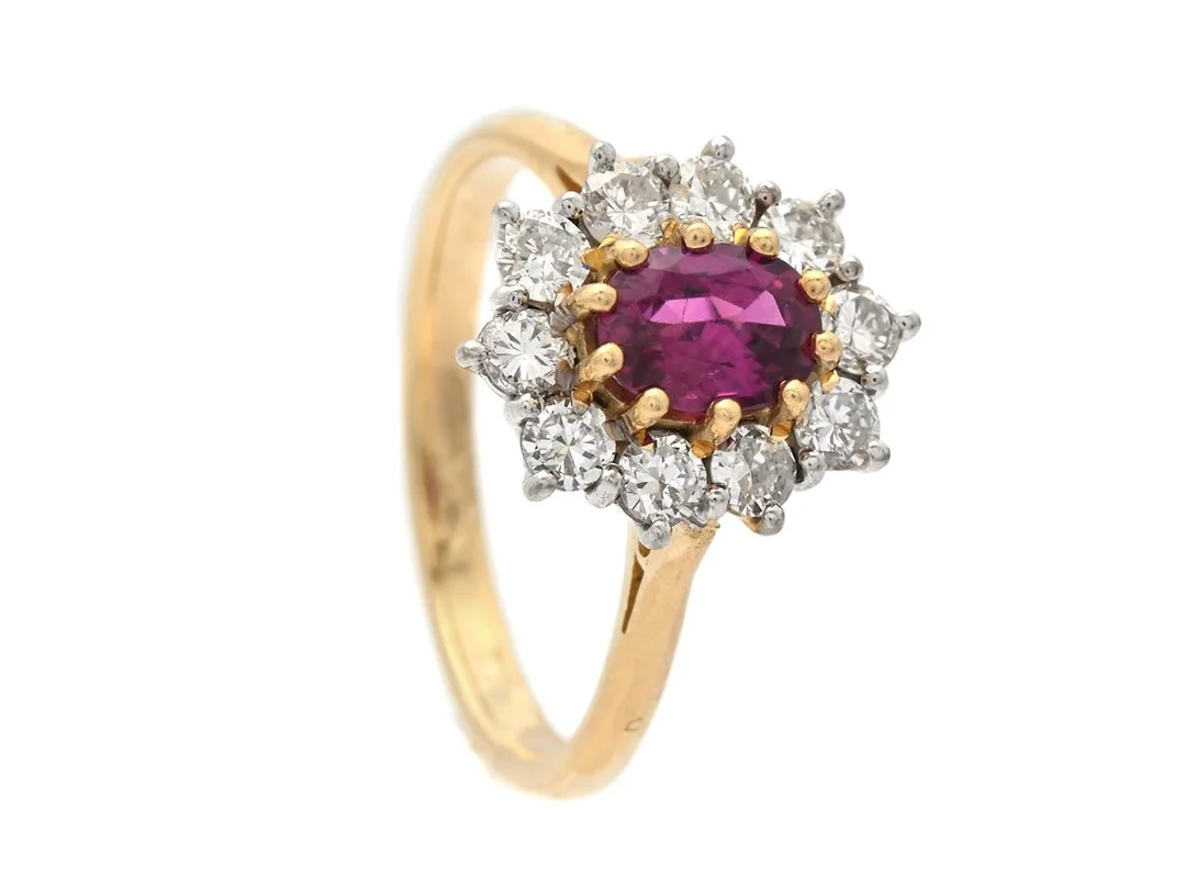 CARMOSÉRING, 18K guld/vitguld, ovalslipad rubin ca 0,60 ct, 10 briljantslipade diamanter ca 0,50 ctv, ca W/VS-SP, stl 17,25 mm, vikt 4,3 g, enstaka diamanter med skador och nagg. — Smycken/Carmoséring — Kaplans