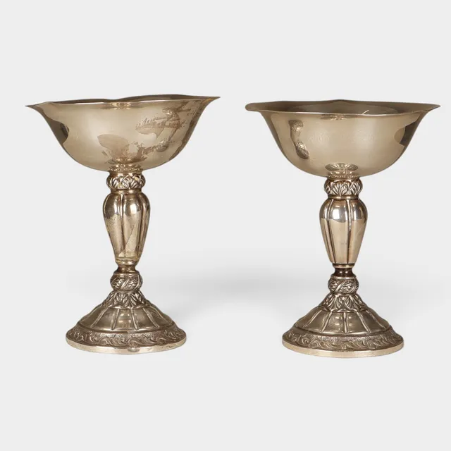 Pareja de copas en plata con fuste decorado con motivos vegetales en relieve.