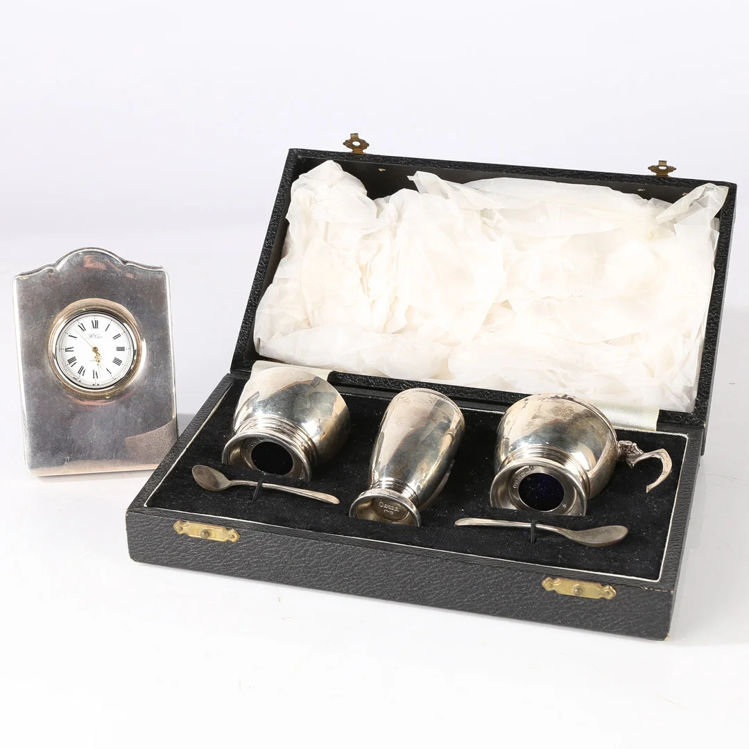 AN ELIZABETH II SILVER CONDIMENT SET, AN ELIZABETH II SILVER MOUNTED DESK CLOCK. — Silver — Bishop & Miller