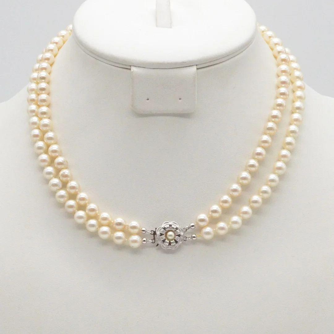 PERLENCOLLIER MIT EINEM STECKVERSCHLUSS AUS STERLINGSILBER, CREMEFARBIGE IMITATPERLEN, ZWEIREIHIG, EINZELN HANDGEKNÜPFT, UM 1950. — Necklace — Kunst- und Auktionshaus Kleinhenz