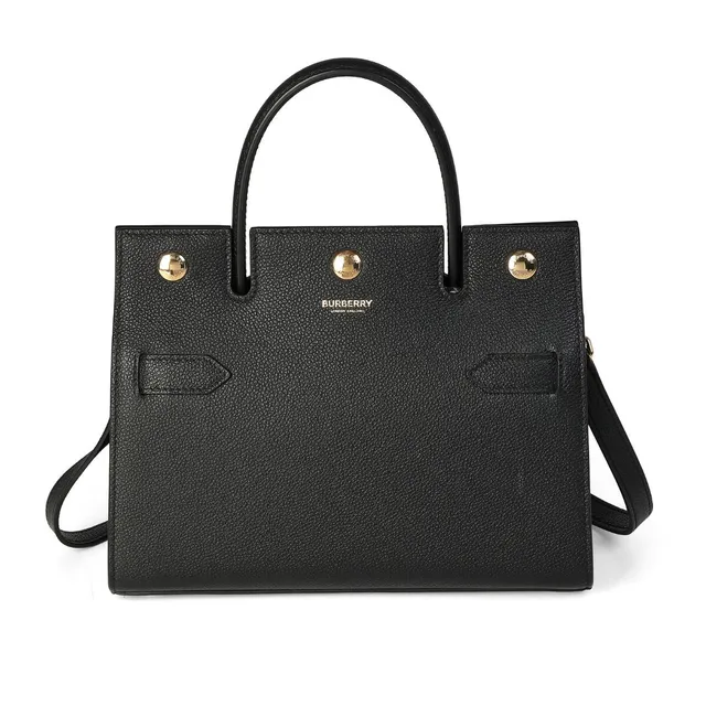 “Mini Title Bag” of black leather with gold-tone hardware, detachable shoulder strap, short handle, two compartments with an interior pocket and beige lining. H. 20 x W. 24 x D. 10 cm.
