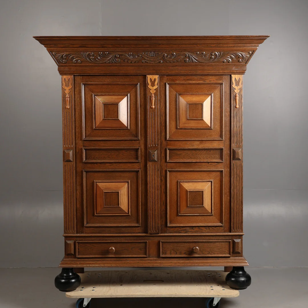 A 20TH CENTURY CARVED OAK TWO-DOOR ARMOIRE. — Cupboards, Cabinets & Shelves — Bishop & Miller
