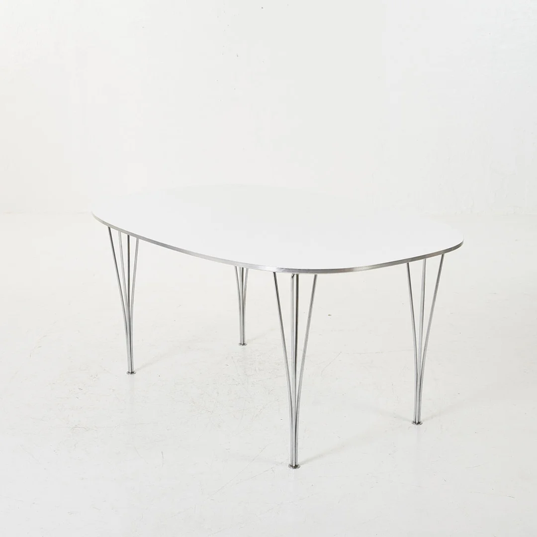 BRUNO MATHSSON/ PIET HEIN. Matbord, ''Superelips'', tillverkad av Fritz Hansen Danmark, vit laminat, aluminiumkant, 4 kromade spännben, bläck och etikettsmärkt. — Tables — Stockholms Auktionsverk Magasin 5