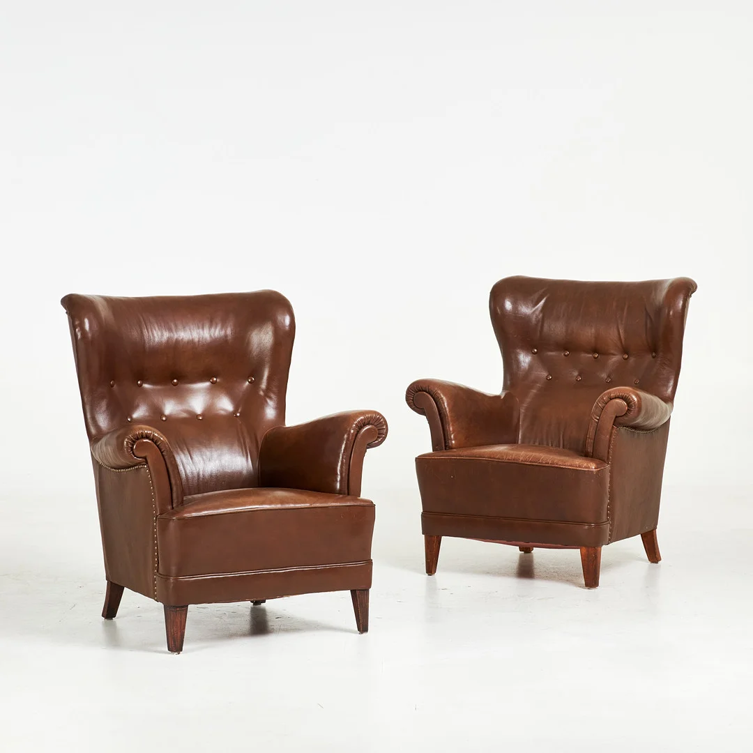 CARL MALMSTEN. "Häggbom", fåtöljer, 1 par, 1900 talets mitt, skinnklädsel, pärlspik, betsade ben i trä. — Armchairs & Chairs — Stockholms Auktionsverk Sickla