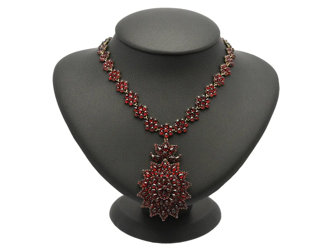 COLLIER, vitmetall, granater, hårgömma, avtagbart hänge, 1900-talets början, längd 40,5 cm, vikt 37,8 g, nagg, två granater saknas på hänget, tidigare broschmekanism på hänget saknar nål. — Smycken/Collier — Kaplans